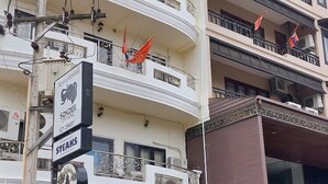 Um hotel com várias varandas, um letreiro com a inscrição 'Sokdee City Hotel' e um restaurante chamado 'Steaks'.