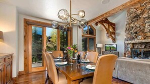 A dining area with a wooden table, chairs, and a chandelier.