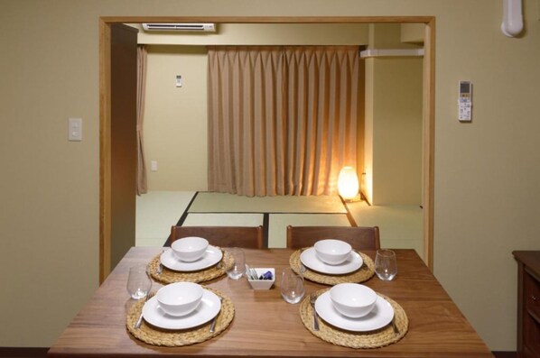 Enjoy meals in this cozy dining area with a table for four, featuring a traditional woven placemat under each setting.