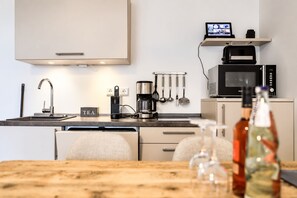 Uma cozinha moderna equipada com lava-louças embutida, máquina de café e micro-ondas.