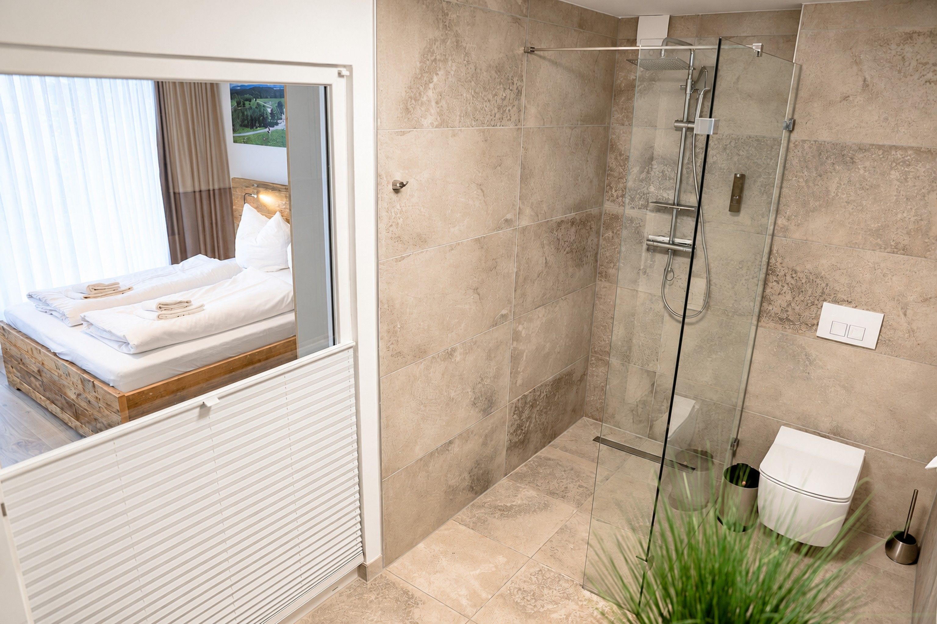 A modern bathroom with a glass shower enclosure, a toilet, and a bidet.