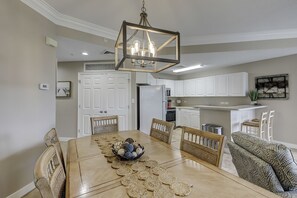 A dining area with a wooden table, woven placemats, and wicker chairs.