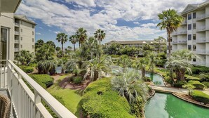 Ein Resort mit mehrstöckigen Gebäuden, einem Schwimmbad, Palmen und einem gepflegten Garten.