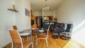 A modern living room with a dining area, a kitchen in the background, and a seating area with a sofa and chairs. - Feet in the water! (Duingt)