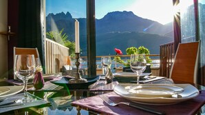 A table set for dining with a view of mountains and a body of water. - Feet in the water! (Duingt)