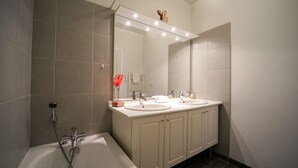 A modern bathroom with two sinks, a large mirror, and a shower. - Feet in the water! (Duingt)