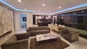Una sala de estar moderna con un conjunto de sofá, una mesa de centro y una zona de comedor con sillas.