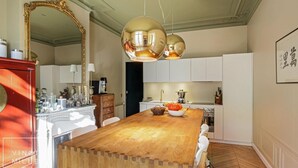 Eine geräumige Küche mit einer Holztheke, weißen Schränken und einem großen Spiegel.