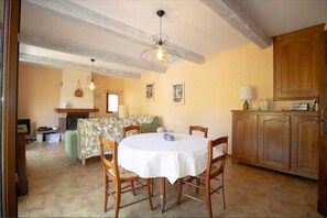 Enjoy meals in this inviting dining area with a round table for four, a fireplace, and beautiful artwork on the walls.