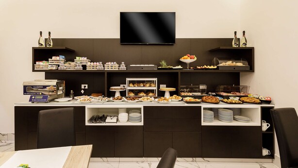 Un buffet proposant une variété de plats et un téléviseur fixé au mur.