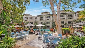 Un complexe hôtelier doté d’espaces de détente en plein air, d’une piscine et d’un bâtiment à plusieurs étages.