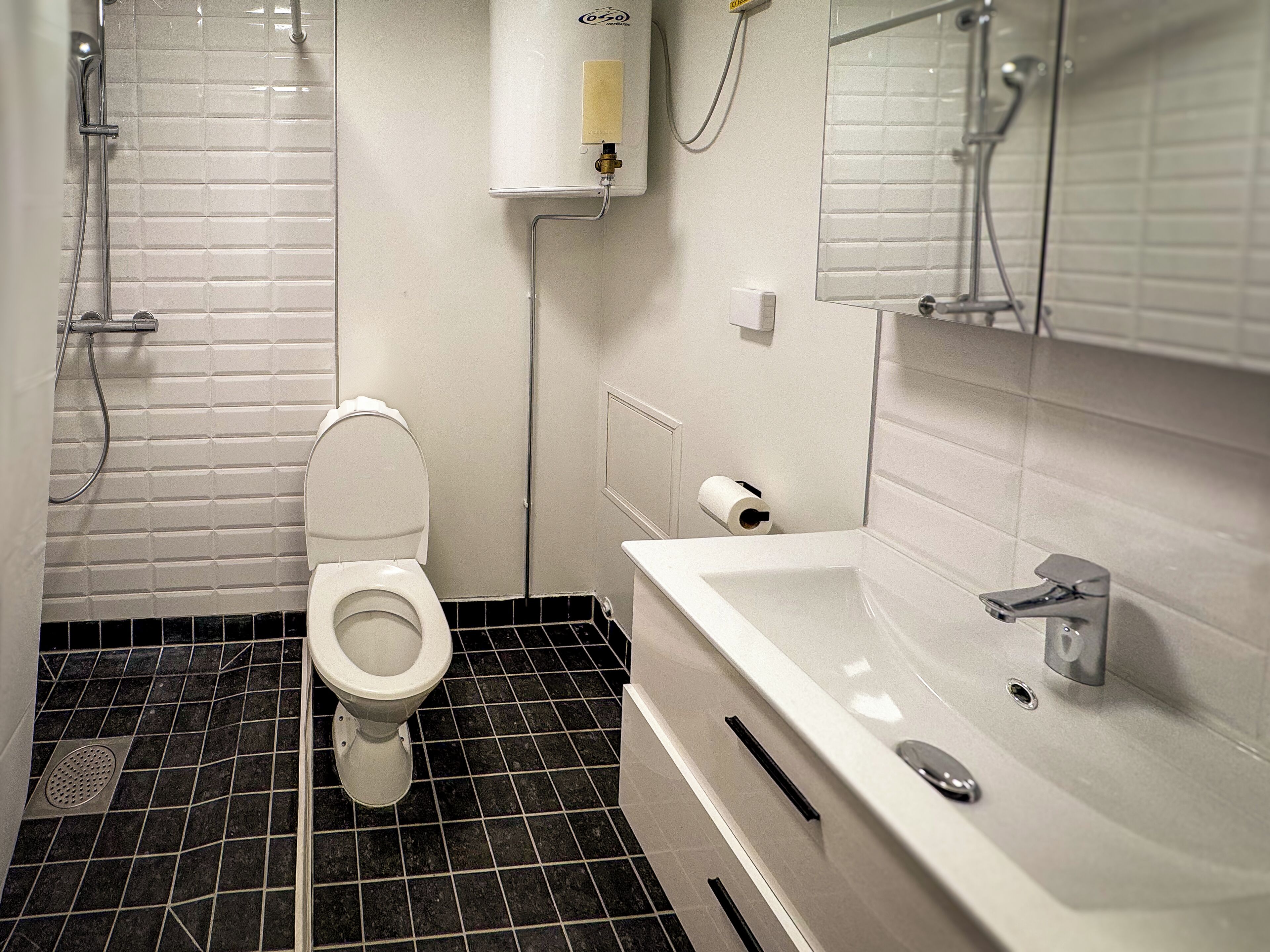 Een badkamer met toilet, bad en douche.