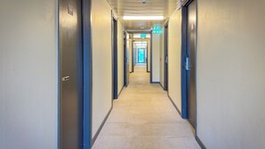 A long, narrow hallway with carpeted floors and doors on both sides. - Jönköping Hotel Apartments (Jonkoping)