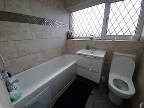 Een badkamer met een bad, een wastafel en een toilet.