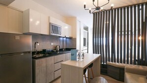 A modern kitchen with a built-in oven, a coffee machine, and a dining area with a bench and a table.