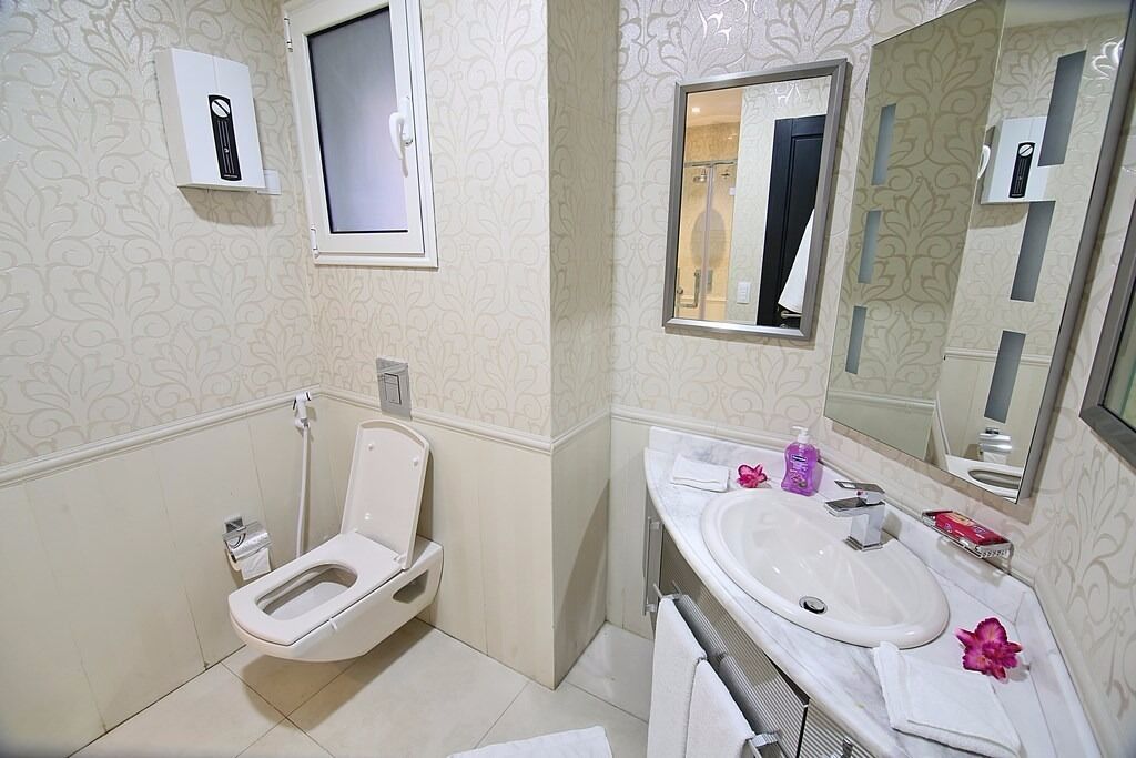 Ein Badezimmer mit Toilette, Waschbecken und Spiegel.
