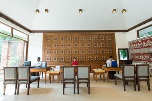 Una biblioteca con paneles de madera, varias mesas y sillas.