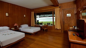 A hotel room with two beds, a dining table, and a view of a vineyard. - Bagan Thande Hotel (Nyaung-U)
