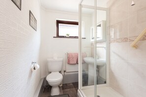 Un bany amb vàter, bidet i plat de dutxa de vidre.