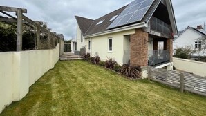 Ein eingeschossiges Haus mit Satteldach, Solaranlage, einem Backstein-Schornstein und einer kleinen Veranda.