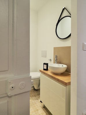 Ein Badezimmer mit Waschbecken, Spiegel und Toilette.