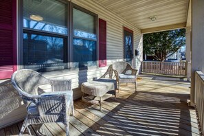 A covered porch with wicker furniture and a view of the neighborhood. - North St Neighborhood Character Home Near Downtown (Appleton)