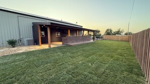 A residential property with a fenced backyard, a covered patio, and a large garage. - Country Lodge (Great Bend)