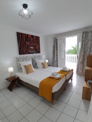 A hotel room with a bed, a bedside lamp, a painting on the wall, and a view through the window. - STUNNING 4-Bedroom Home with a View of the St. François Lagoon (st françois)