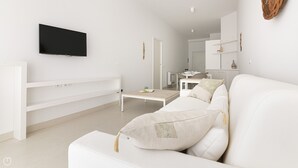 Un saló modern i minimalista amb un sofà blanc, una taula de centre i un televisor de pantalla plana muntat a la paret.