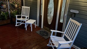 A wooden porch with two rocking chairs and a welcome sign. - 2/2 Apt downtown in restored historic home yr 1891 (Ocala)