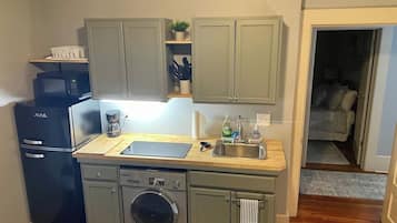 Une cuisine compacte équipée d’un lave-vaisselle, d’un four à micro-ondes et d’un lave-linge.