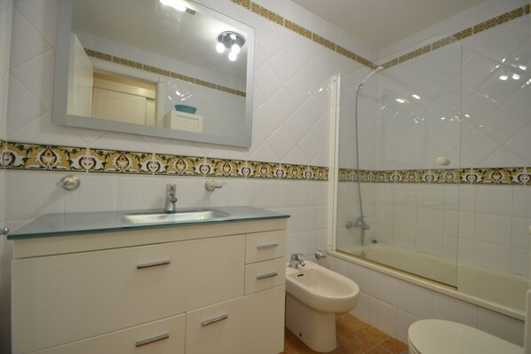 A bathroom with a glass shower enclosure, a bidet, and a sink with a mirror above. - Canela Park 200 - Two Bedroom Apartment, Sleeps 5 (Punta del moral)