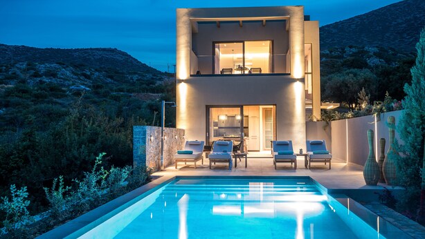 A modern two-story house with a swimming pool, outdoor seating, and a view of the surrounding landscape. -  Grace Villas Collection (Hersonissos)
