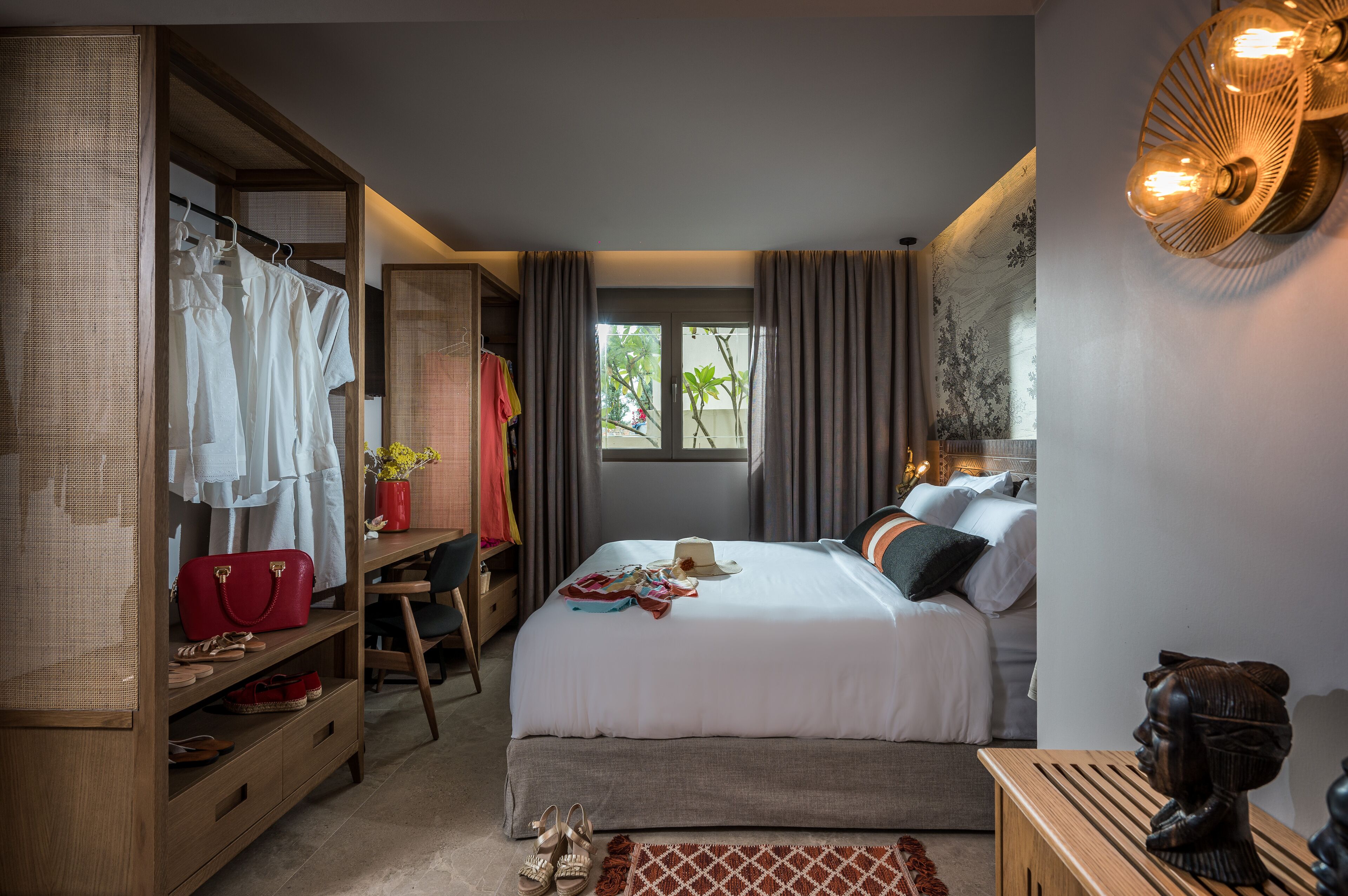 A bedroom with a bed, a desk, and a wardrobe.