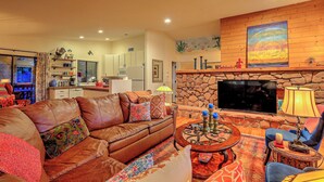 A cozy living room with a stone fireplace, a flat-screen TV, and a comfortable seating area. - Luxury Sedona Home with Finnish Sauna and Hot Tub (Sedona)