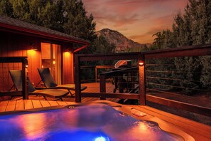 A hot tub on a wooden deck with lounge chairs, a barbecue grill, and a mountain view. - Luxury Sedona Home with Finnish Sauna and Hot Tub (Sedona)