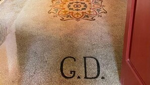 A hallway with a patterned carpet, a wooden door, and a small table with glasses. - The Musician Angels (Sogliano Cavour)