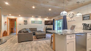 A modern kitchen with wooden cabinetry, a built-in island, and pendant lighting.