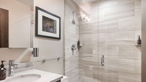 A modern bathroom with a glass-enclosed shower, a marble sink, and a framed picture on the wall. - Vail 21 407 - 2 Bedroom Diamond (Vail)