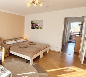 A bedroom with a bed, bedside lamps, a small rug, and a picture on the wall. - Comfortable Apartment in Langenargen (Langenargen)