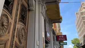 Fachada de edificio con detalles arquitectónicos ornamentales, incluyendo molduras decorativas y un letrero que dice 'VisionOttica Mirante'.