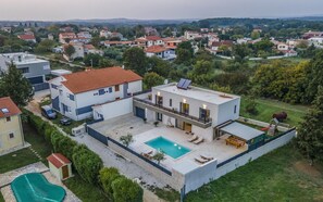 Un immeuble résidentiel moderne doté d’une piscine, d’un patio couvert et offrant une vue sur un quartier résidentiel.