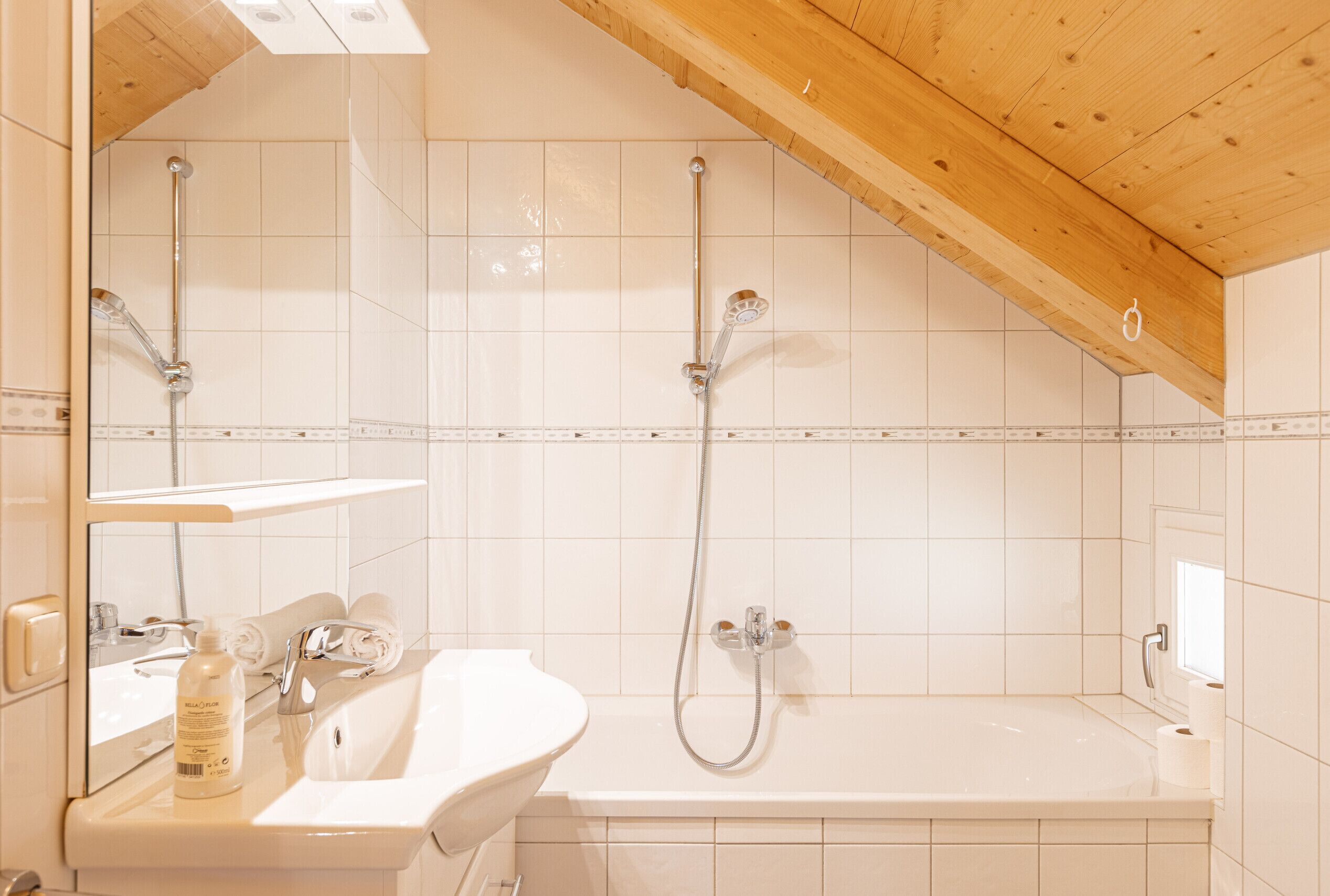 Een badkamer met een bad, een wastafel en een douche.