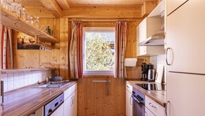 Una cucina compatta con mobili in legno, una finestra e un lavandino.