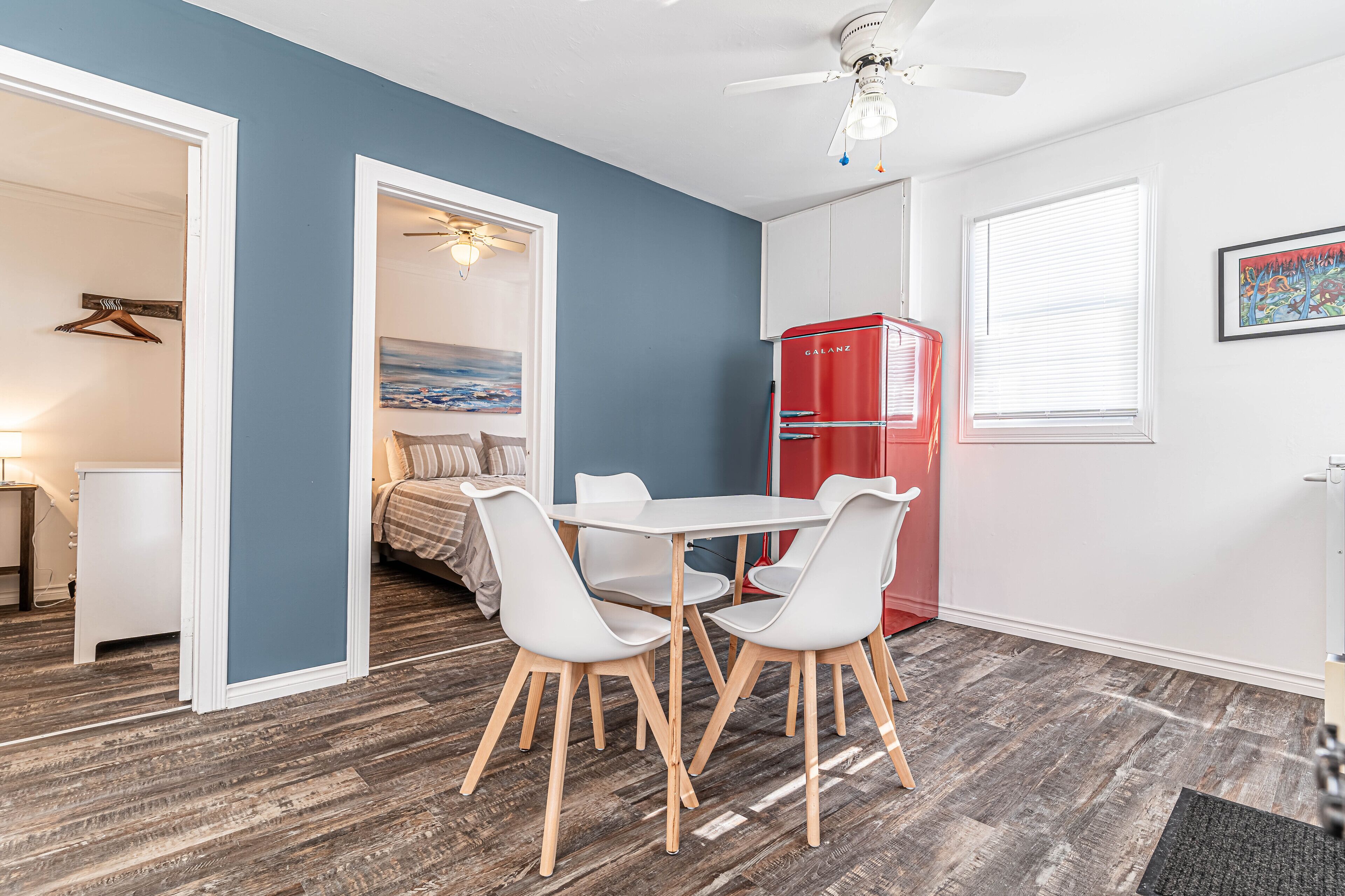 Un espacio habitable compacto con comedor, kitchenette y dormitorio.
