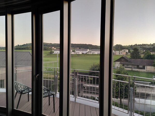 A balcony with a view of a green field and buildings. - Hirschen Oberkirch (Oberkirch)