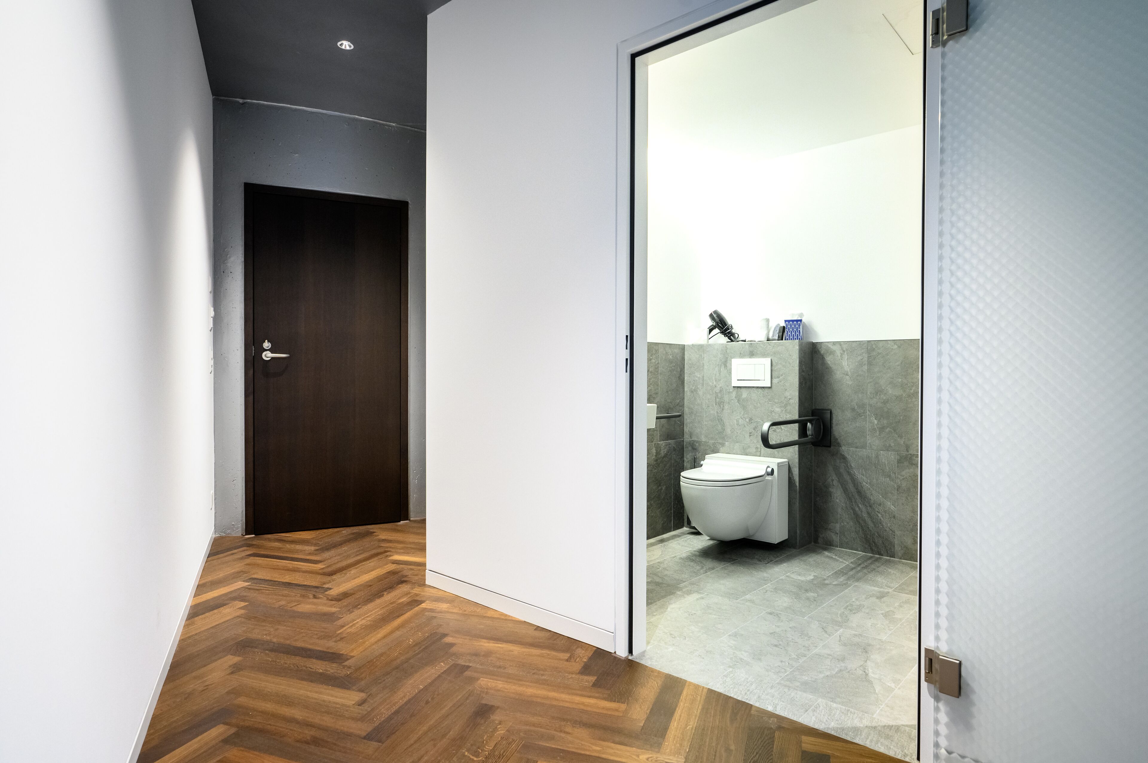 Ein modernes Badezimmer mit Toilette, Dusche und einer Glasabtrennung.