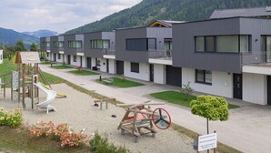 Un edificio moderno con varias unidades, un parque infantil y un letrero que indica acceso privado.
