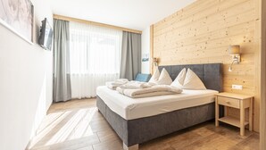 Un dormitorio moderno con una cama grande, un panel de pared de madera y una mesita de noche con lámpara.