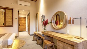 Een moderne badkamer met een houten wastafelmeubel, een ronde spiegel en een handdoekrek.